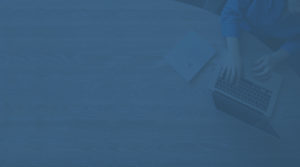 Background image of someone typing on a laptop