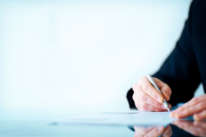 Image of a business man hand writing on paper
